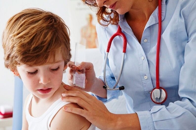doctor examines a child with papilloma of the body